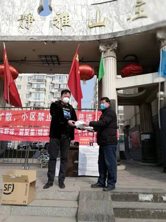 (上图)民建会员刘凤阳（左）为社区捐口罩.jpg